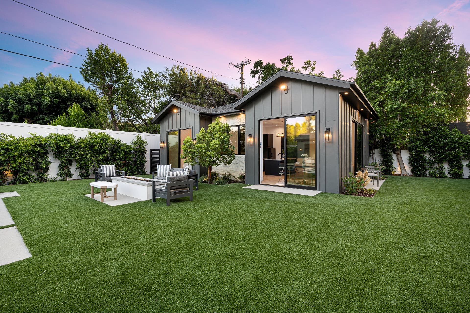 Finished backyard with a modern fire pit and detached ADU at sunset in the Sacramento area
